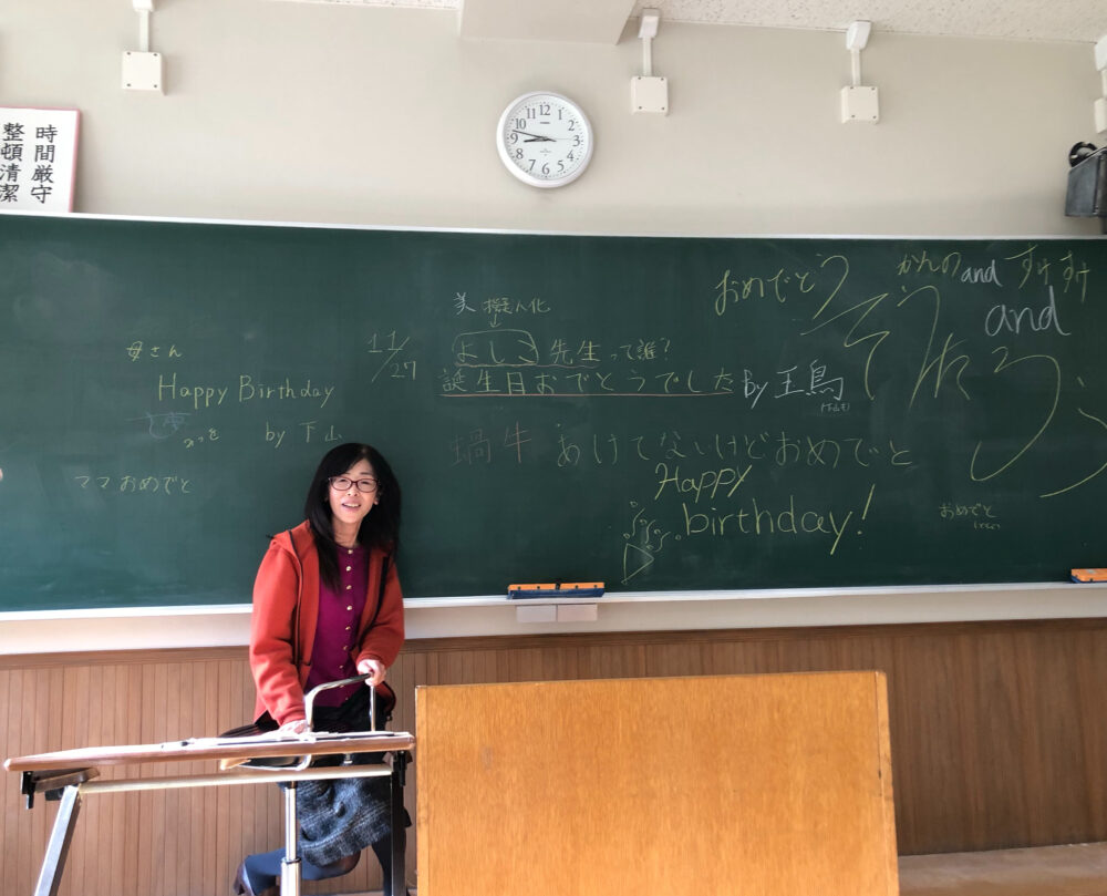 学生たちからメッセージが描かれた黒板と大槻先生